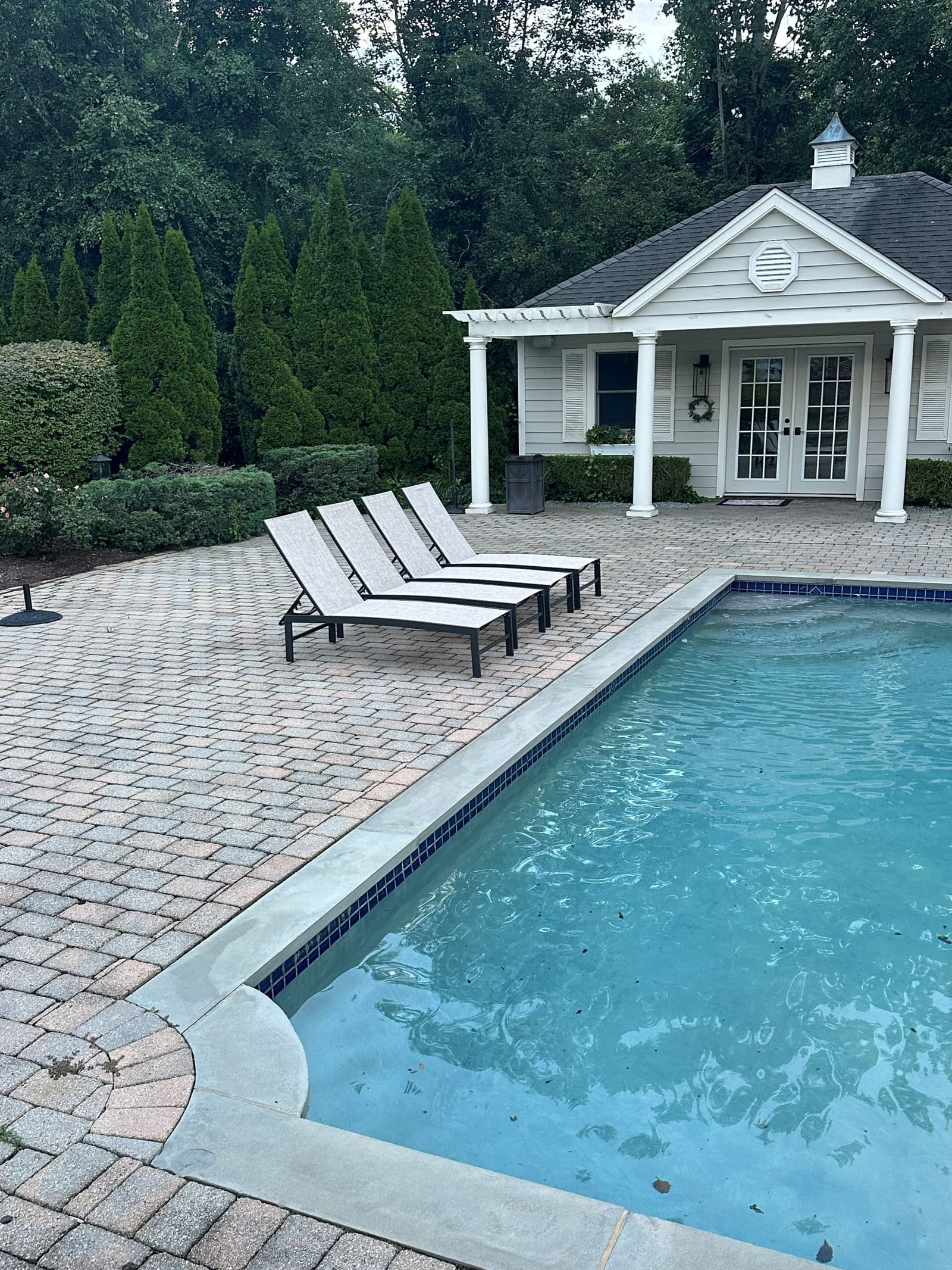 Poolside patio with loungers installed by Handy Hippo