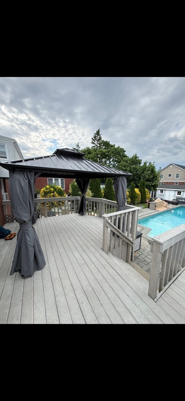 Hardtop gazebo assembled on a deck beside a pool